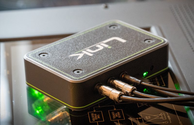 Link with three control cables plugged into its ports, sitting on top of a preamplifier